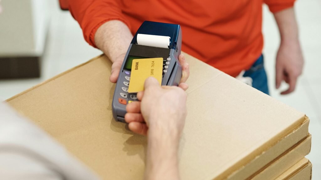 pexels-photo-4393443-4393443 Contactless payment for pizza delivery with a masked courier using a card reader.